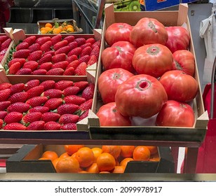 In a greengrocer on the street there are strawberries and rose tomato from Spain