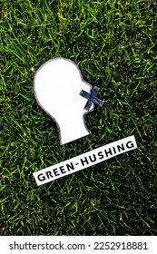 green-hushing concept about companies staying silent about their environmental footprints and policies, text and face with  mouth shut on green grass - Shutterstock ID 2252918881