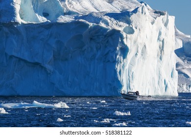 Greenland. Centuries-old Thicknesses Of Glaciers. Boat In Front Of Icebergs Research Of A Phenomenon Of Global Warming