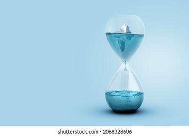 Greenland glacier melting and global warming concept. Iceberg melting in a glass hourglass, time and the rising temperature of planet Earth. Creative idea. Heightening worldwide flood risks
