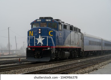 Greensboro, NC / USA - February 10, 2018: Amtrak 74 Piedmont Train Passing By In Greensboro North Carolina Pulling Passenger Cars On A Fog Covered Day