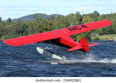 Greenville, ME, USA - Sep 08 2018:  Taylorcraft BC-12 Floatplane Vintage Light Aircraft Taking Off from Moosehead Lake, Greenville, Maine.