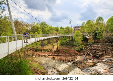 GREENVILLE, SOUTH CAROLINA - APRIL 7, 2015:  The Liberty Bridge is a landmark pedestrian bridge with a deck supported by a single suspension cable at Falls Park on the Reedy in downtown.