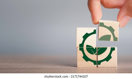 Greenwashing concept. Green leaf and gear icon in wood cube Company investing more time and money on marketing their products or brand environment. copy space for background or text. - Shutterstock ID 2171744107