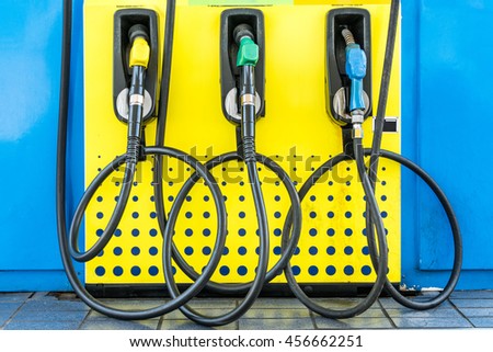 Green,Yellow and Blue fuel nozzles in the fuel dispenser in the Petrol Station