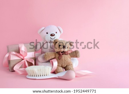 Greeting card for baby girl birth with teddy bears and baby hair brush on pink background. Image with copy space