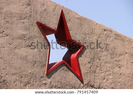 Greeting card with the day of the defender of the fatherland. February 23. red five-pointed star in a concrete wall against a blue blue sky. Victory day. Mock p for copy spase for text.