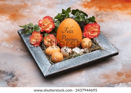Greeting card Happy Easter: Inscribed Easter egg with quail eggs and flowers. Spanish inscription translates as Happy Easter.
