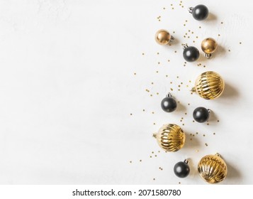 Greeting card - happy new year and Merry Christmas, gold stars glitter and black and gold christmas balls on white textured background. Minimal holiday concept. Top view. Flat lay - Shutterstock ID 2071580780