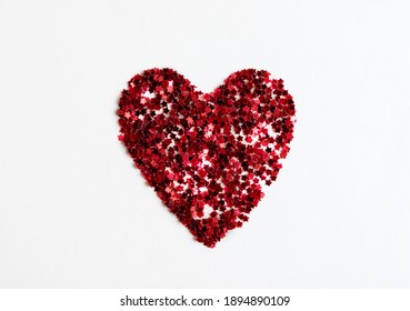 Greeting card heart made of red confetti on a white background