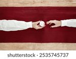 Greeting card for Independence day of Latvia in 18 of November and 4 of May in national colours depicting sharing light with a candle with each other creating a flag of Latvia with arms in linen shirt