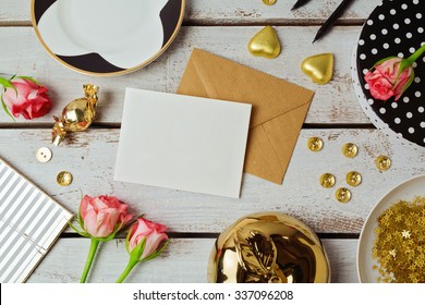 Greeting Card Mock Up Template With Rose Flowers And Chocolates On Wooden Background. View From Above