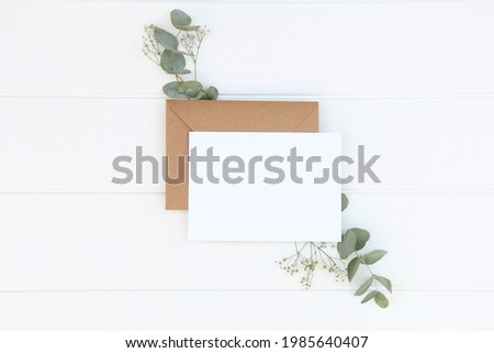 Greeting card mockup with craft envelope with eucalyptus.   Card mock-up 
