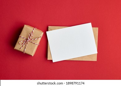 Greeting Card Mockup With Envelope And Gift Box On Red Paper Background