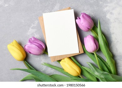 Greeting Card Mockup With Envelope And Tulip Flowers On Grey Concrete Background, Top View, Copy Space