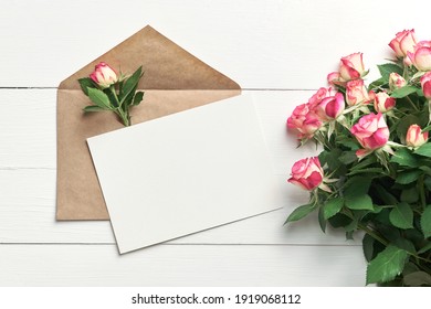 Greeting Card Mockup With Fresh Roses On White Wooden Background, Top View, Copy Space