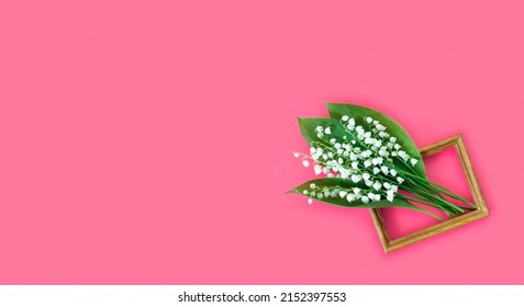 Greeting card for mother's day with bouquet of tender lilies of the valley with wooden frame  on  pink background. Spring nature concept.