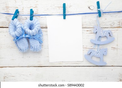 Greeting children form with blue booties and wooden horse. Flat lay