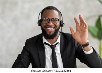 Greeting Concept. Portrait Of Excited Young Black Business Man In Suit Waving Hello With Hand At Camera, Using Laptop At Home Office. Cheerful Guy Saying Hi Or Goodbye During Video Call, Webcam View