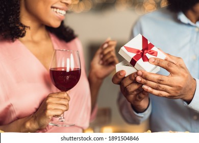 Greeting With Holiday. Close Up Of Unrecognizable African American Guy Giving Present To His Smiling Girlfriend, Opening Box With Jewelry Gift. Beautiful African American Couple Celebrating Together