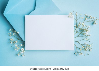 Mockup cartão de convite ou saudação, branco vazio com decoração floral no fundo azul, espaço de cópia. Elegante maquete criativo com flores brancas gypsophila. Projeto do dia das mães.