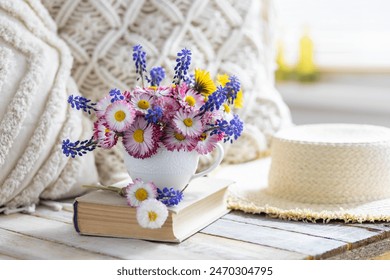 Greeting postcard with bright summer or spring flowers in a cute cup. Congratulations for Mother's or Women's day, birthday or anniversary. Countryside decor, old book, wooden background, straw hat - Powered by Shutterstock