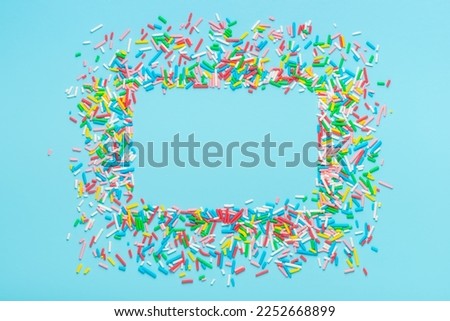greeting wreath of colorful sprinkles on blue background, festive invitation for Valentines day, birthday, holiday and party time.