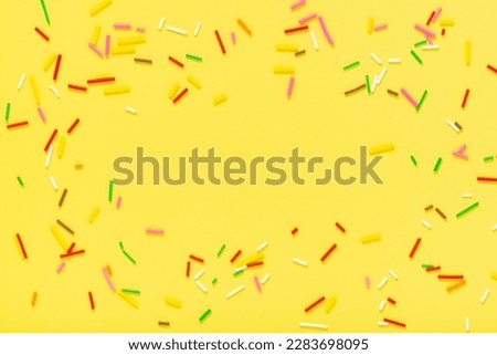 greeting wreath of colorful sprinkles on yellow background, festive invitation for Valentines day, birthday, holiday and party time.