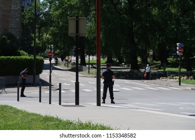 Grenoble, France – June 10, 2017: Photography Depicting Policemen Blocking A Street And Ensuring The Security And Safety During The Cycling Event 'Le Critérium Du Dauphiné 2017'. 