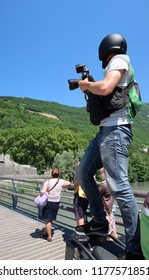 Grenoble, France – June 10, 2017: Photography Depicting A Professionnal Photograph Climbing On A Motorcycle To Take A Picture During The Cycling Event 'Le Critérium Du Dauphiné 2017'