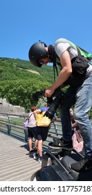 Grenoble, France – June 10, 2017: Photography Depicting A Professionnal Photograph Climbing On A Motorcycle To Take A Picture During The Cycling Event 'Le Critérium Du Dauphiné 2017'