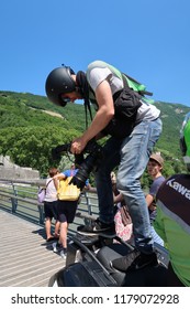 Grenoble, France – June 10, 2017: Photography Depicting A Professionnal Photograph Climbing On A Motorcycle To Take A Picture During The Cycling Event 'Le Critérium Du Dauphiné 2017'