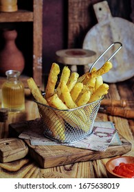 Gresik /Indonesia-march 18 2020 : Potato Cheese Stick / Long Potato Cheese On Wire Strainer Abd Wood Background. Now It's Popular Snack In Indonesia. Selective Focus, Grainy 