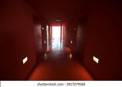 Grevesmuehlen, Germany, September 17, 2020: Corridor All Over Red Painted With Walls, Floor And Doors Is Leading To Bright Light In The Former Malt Factory, Copy Space