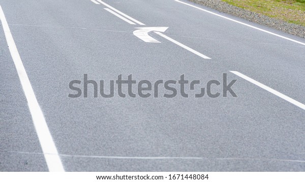 grey asphalt road with markings for drivers,\
traveling by car