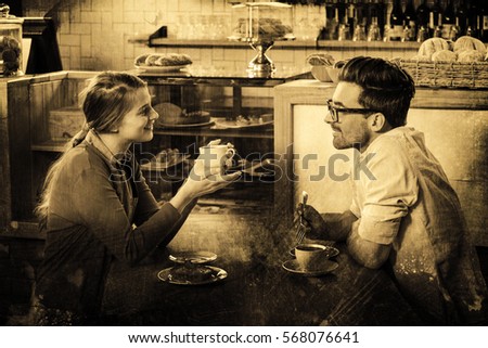Grey background against couple sitting at table and talking