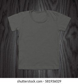 Grey blank t-shirt on dark wood background