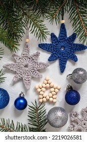 Grey Blue Crochet Handmade Christmas Tree Toys , Beaded Star, Baubles And Fir Branches On A White Background. Handmade Knitted Christmas Decor. Homemade Christmas Ornaments.