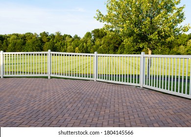 grey and brown paving stone and white vinyl fence outdoor residential