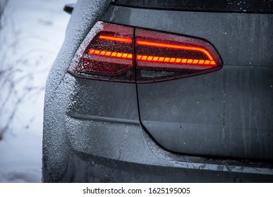 Grey car back lights in winter snow and dirt 