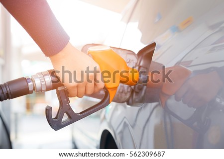 Grey car at gas station being filled with fuel on thailand