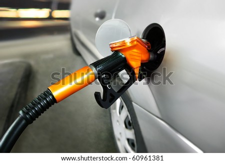grey car at gas station being filled with fuel