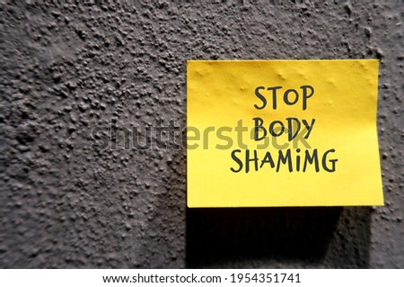 Grey cement concrete rough texture wall background with text STOP BODY SHAMING , no more humiliation about another body shape , size or criticizing appearance through negative judgment