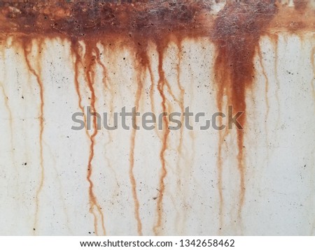 grey cement wall with red rust dripping down