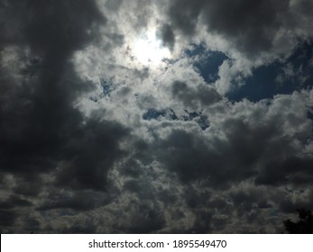grey cloudy sky with rays of sun and a little blue