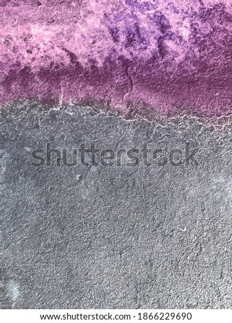 Grey concrete surface with splash of Amethyst colored paint. Abstract universal backdrop with text space