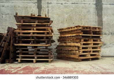 Grey Concrete Wall With Wood Palette. Construction Site. Vintage Effect. 