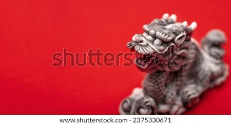 Grey dragon statue on a red background. The symbol of 2024. Happy Chinese New Year.