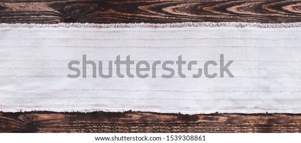 Grey fabric runner on an old wooden\
rustic table background with copy space. Top\
view.