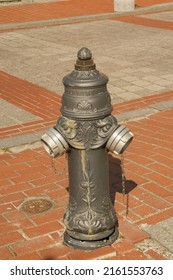 A Grey Fire Hydrant Next To A Grey Car. Old Fire Hydrant..